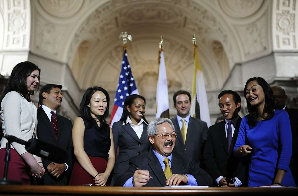 Mayor Edwin M. Lee, center, signs San Francisco's first-ever two-year balanced budget for Fiscal Year 2012-13 and 2013-14 at the City Hall on Wednesday, July 25, 2012 in San Francisco, Calif.