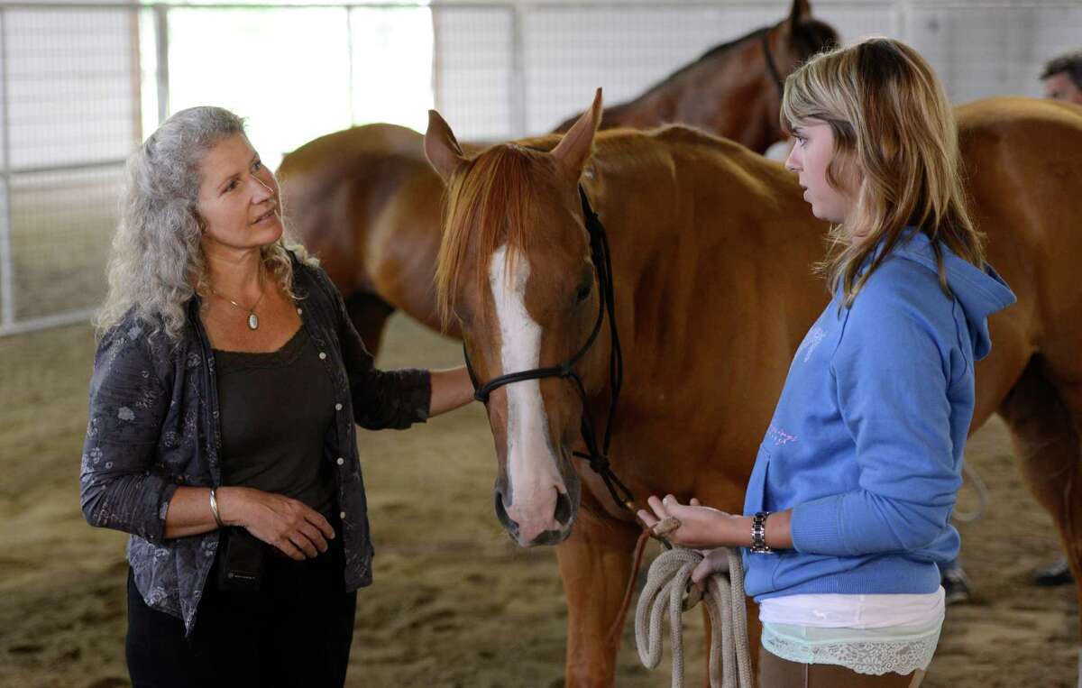 Military suicide widow Rebecca Morrison, right speaks with Saratoga War Horse instructor Melody Squier during her introduction to the Saratoga War Horse Program in Saratoga Springs, N.Y. July 26, 2012 (Skip Dickstein/Times Union)
