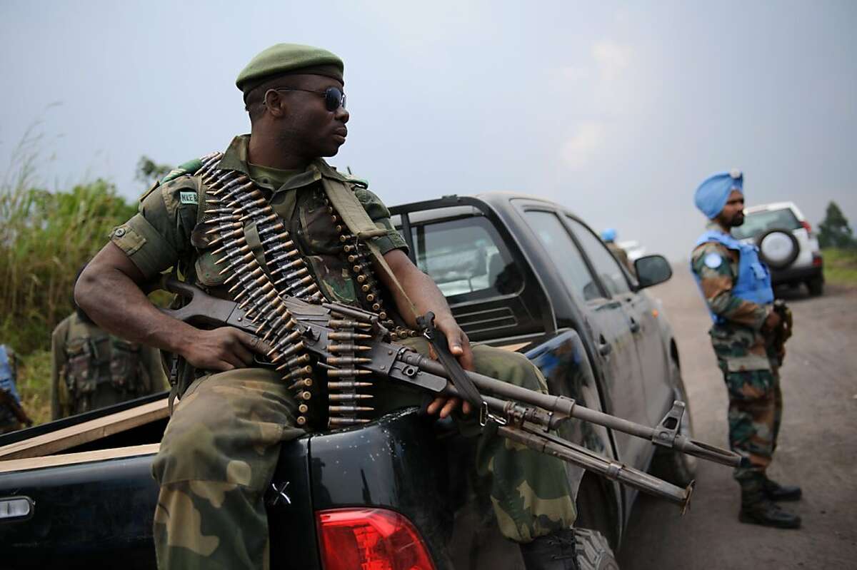 A soldier from the Armed Forces of the Democratic Republic of the Congo (FARDC) sits on a personnel carrier next to a United Nations peacekeeper on the road between Goma and Rutshuru near the village of Kibumba I, around 20km from the city of Goma in the Democratic Republic of the Congo's restive North Kivu province on July 11, 2012. The FARDC has deployed forces around Goma to repel any possible advance by M23 rebels on the provincial capital Goma. AFP PHOTO/PHIL MOOREPHIL MOORE/AFP/GettyImages
