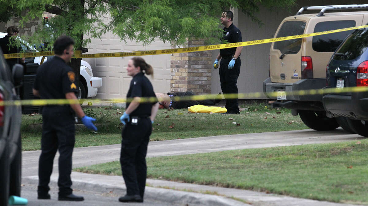 San Antonio police and investigators work at the scene of a fatal shooting July 27 in the 2000 block of Field Wood on the West Side. Officer Michael Garza, who shot and killed the ex-boyfriend of his former roommate, was put on indefinite suspension Tuesday.
