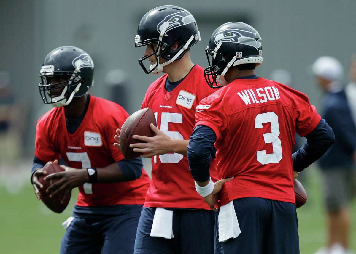 Seahawks quarterbacks Tavaris Jackson, left, Matt Flynn, center, and Russell Wilson, right, stand together on Saturday, the first day of NFL football training camp in Renton.