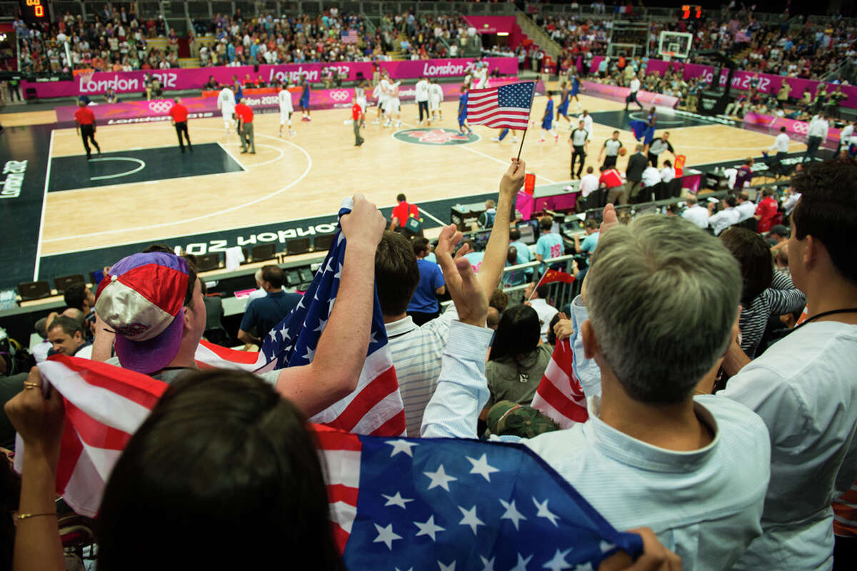 USA fans cheer their team as they leave the field for halftime against France during men's preliminary round basketball at the 2012 London Olympics on Sunday, July 29, 2012.