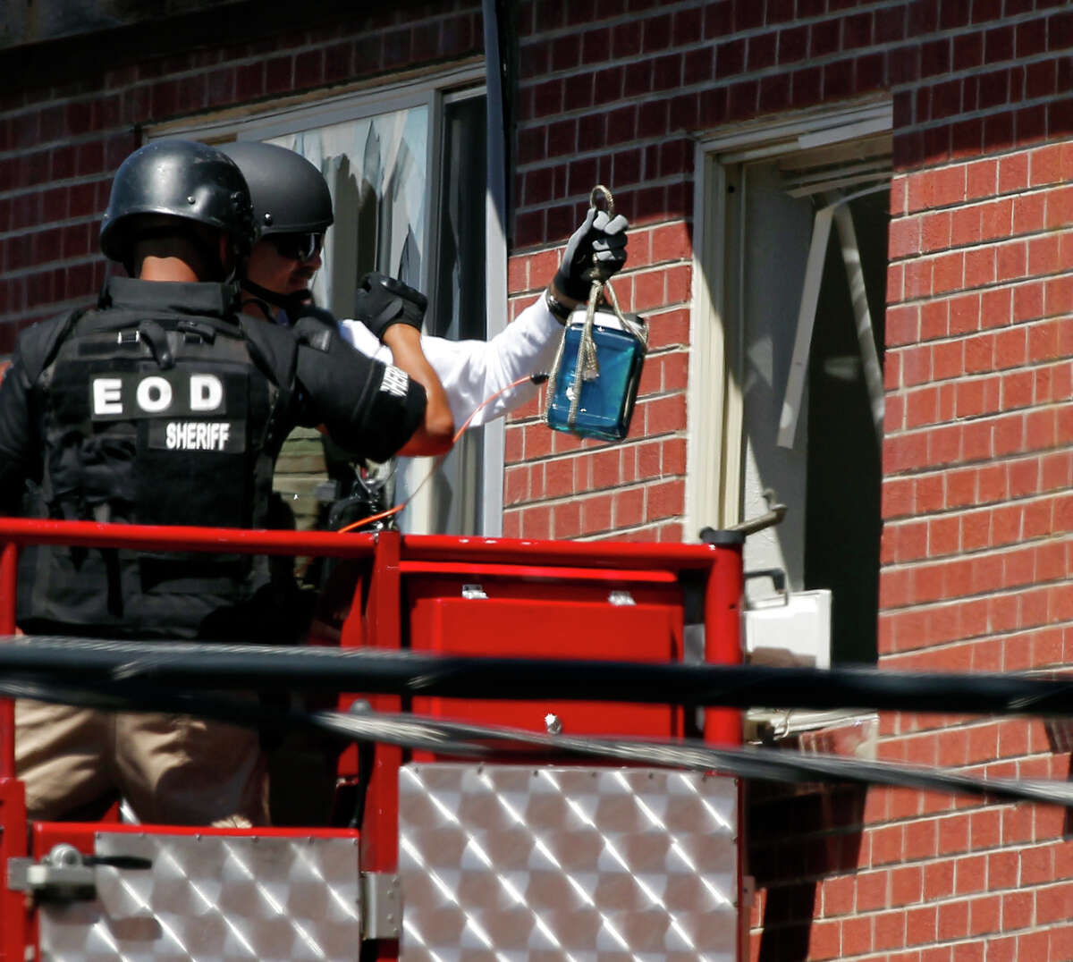 Members of law enforcement prepare to place what ATF sources describe as a "water shot" in the apartment of alleged Aurora, Colo., gunman James Holmes. The "water shot" is placed near an IED and explodes. The blast is used to disable the IED.