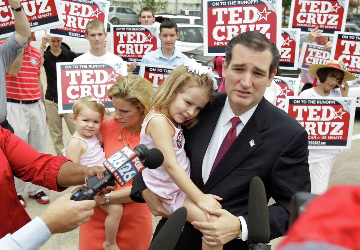 Ted Cruz, Republican candidate for U.S. Senate, holds his daughter, Caroline, 4, as his wife, Heidi Cruz holds their daughter, Catherine, 1, while he speaks to the media before voting during the first day of early voting at the Metropolitan Multi-Service Center, in Houston, Monday, July 23, 2012.