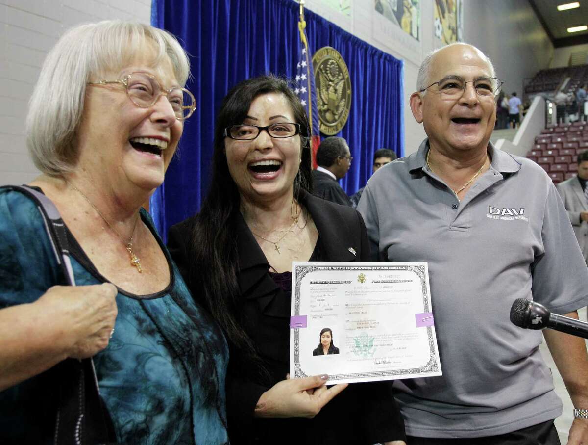 Barbara Garcia, left, Julie Aftab, and Robert Garcia, right, celebrate after Julie's citizenship ceremony at M.O. Campbell Center, 1865 Aldine-Bender, July 31, 2012, in Houston. Robert Garcia was the assistant principle when Julie attended Deer Park High School. Aftab came to the U.S. for medical treatment after being burned with acid by men in Pakistan who accused her of insulting Islam because she is a devout Christian.