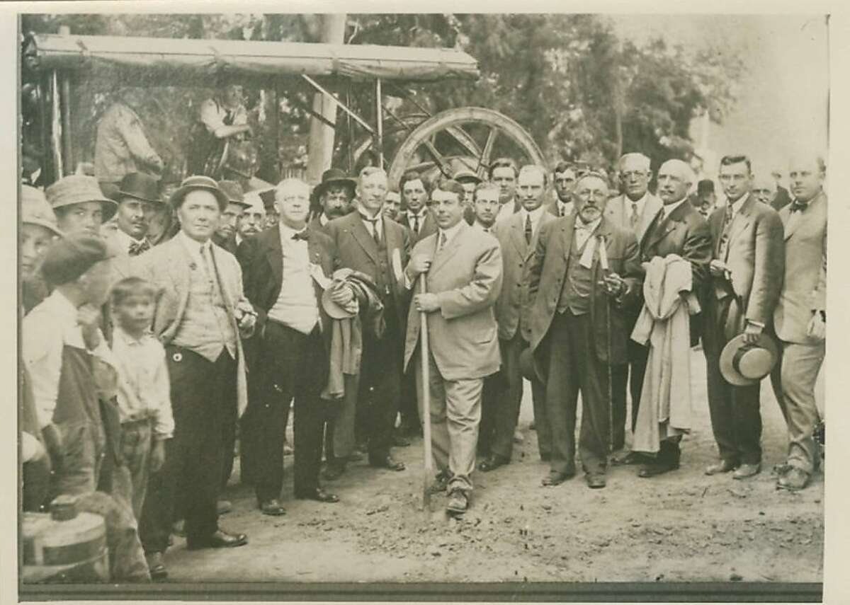California Highway Commission Chairman Burton Towne, with a dozen other officials looking on, broke ground for the El Camino Real near San Bruno Avenue, San Bruno, about 100 years ago.