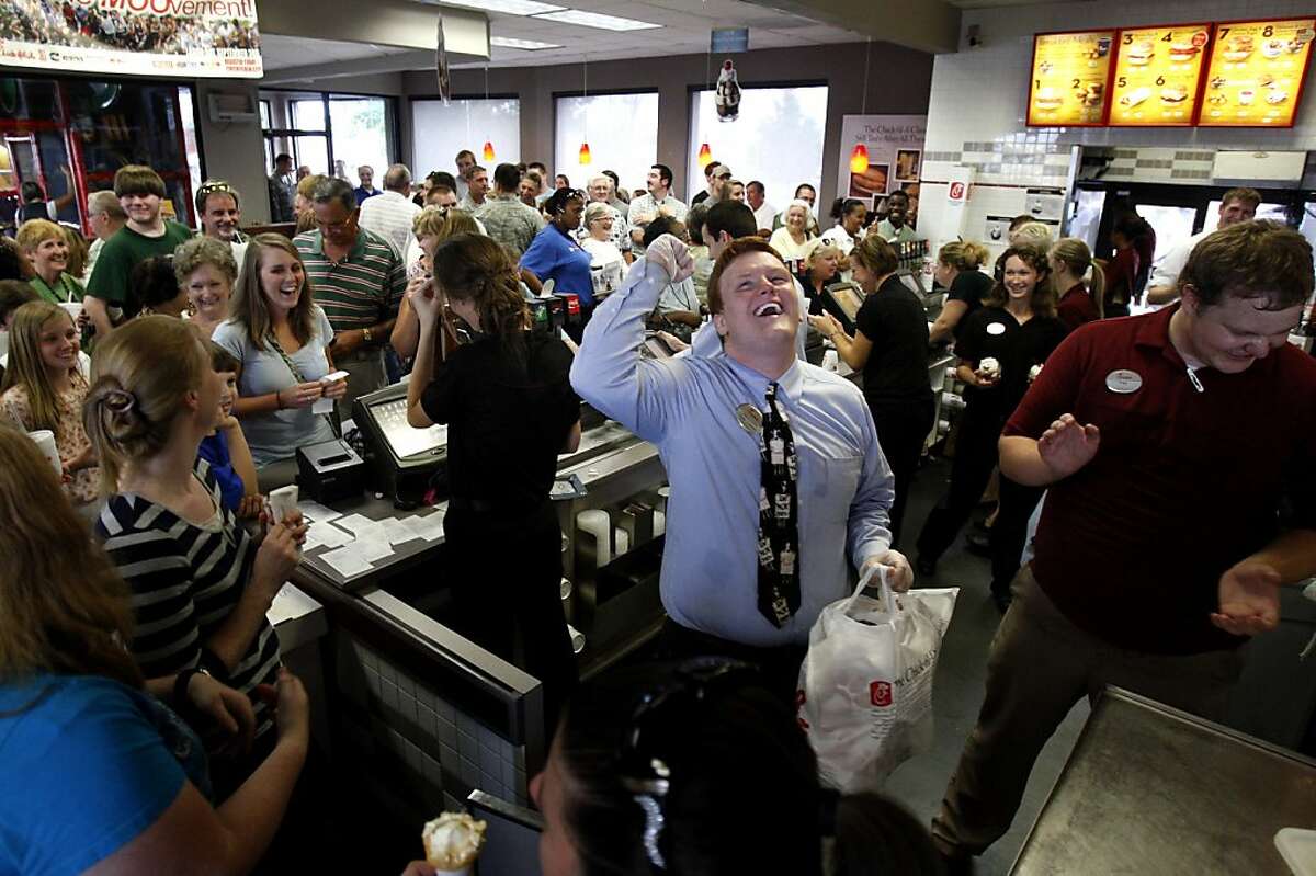 Chick-fil-A team member Dakota Bibbs, center, cheers as customers aid in his search for the owner of an order ready for pick-up in Southaven, Miss. Wednesday, Aug. 1, 2012,. Customers crowded into the Southaven restaurant and patiently waited up to an hour to receive their order in a display of support for the company's stance on marriage and family values. (AP Photo/The Commercial Appeal, Stan Carroll)