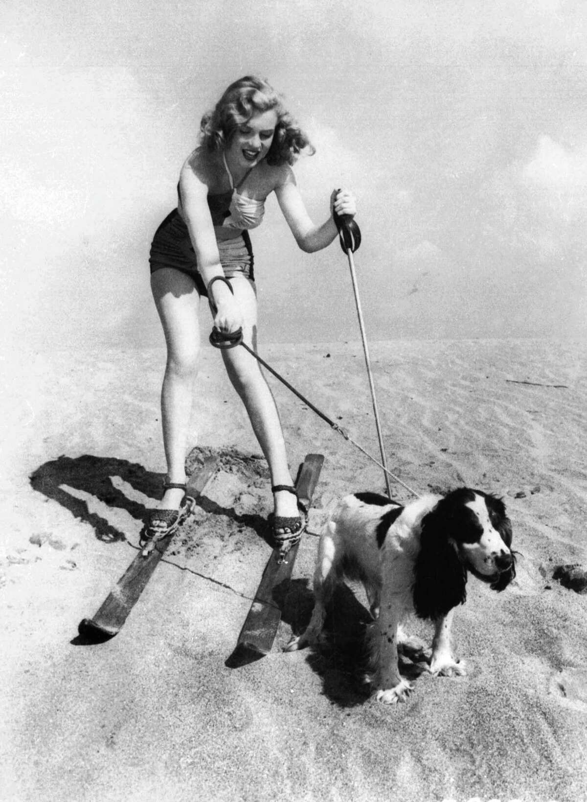 In this January 1, 1947 file photo, starlet Marilyn Monroe plays at the beach with her dog Ruffles.