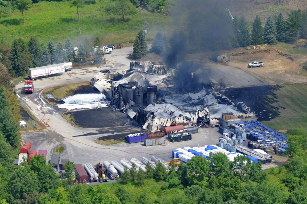 TCI of New York, a transformer recycling company, smolders after it was destroyed by a large on Thursday, Aug. 2, 2012, in West Ghent, N.Y. The fire prompted warnings to residents of the largely rural area along the New York-Massachusetts state line to stay indoors for much of Thursday. Initial tests found no evidence of contamination. (AP Photo/Lance Wheeler)