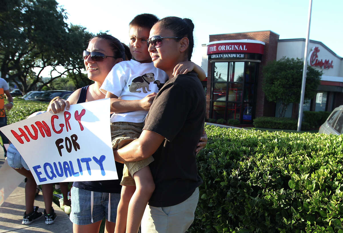 Cristina Rios (left) and her partner Hope Molina along with their six-year-old son, Jude, join in a demonstration in front of a Chick-fil-A on Friday, August 3, 2012. Local pro-same sex activists and supporters demonstrated in front of the Chick-fil-A on Bandera Road and Loop 1604. About 20 demonstrators showed up with signs as a reaction to recent statements made by Chick-fil-A president Dan Cathy on marriage based on his Christian faith. The group of same-sex marriage supporters was significantly smaller than an earlier turnout of patrons which filled the restaurants in support of Cathy and his right to free speech.