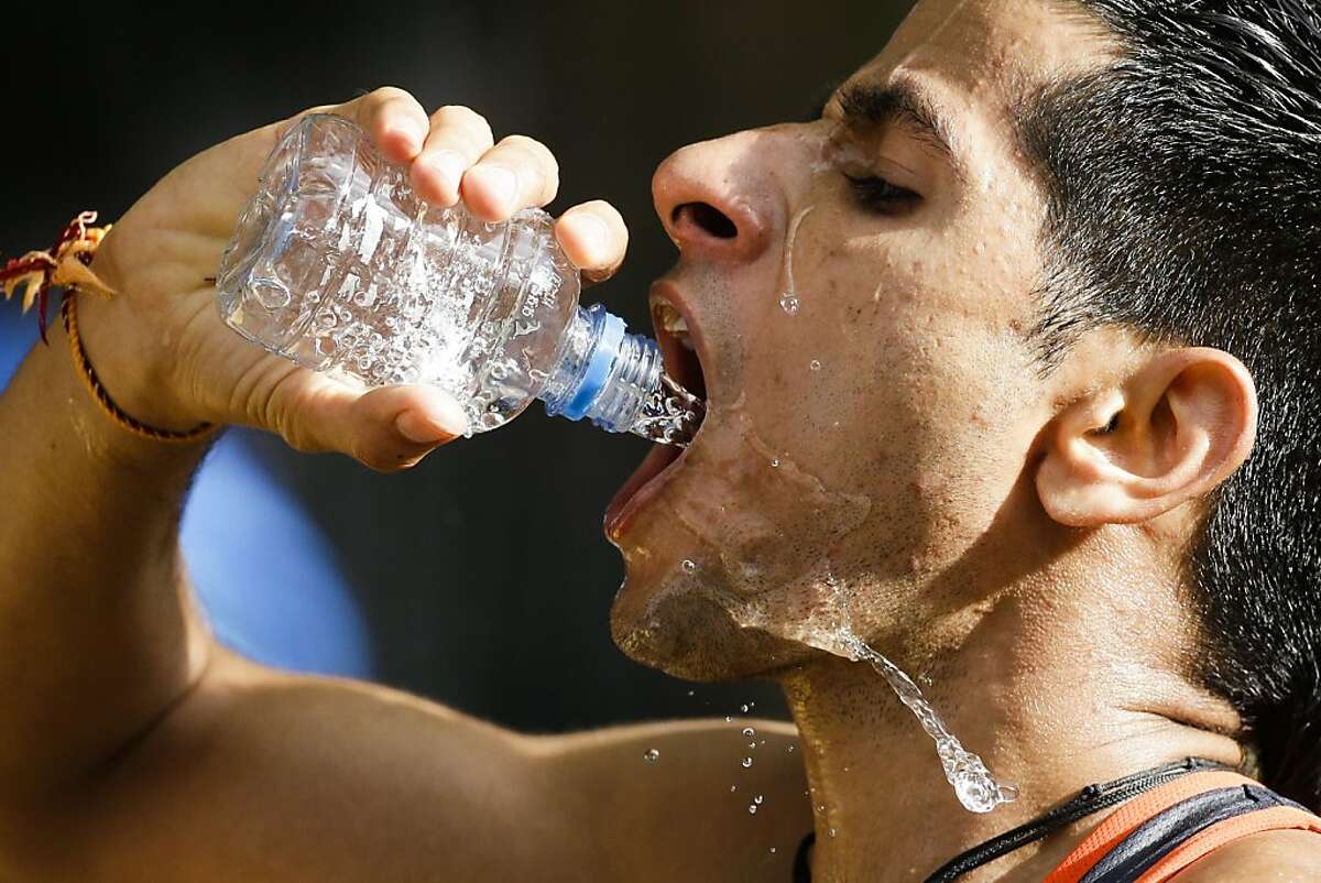 Baljinder Singh of India drinks water while competing in the men's 20-kilometer race walk, at the 2012 Summer Olympics, Saturday, Aug. 4, 2012, in London. (AP Photo/Markus Schreiber)