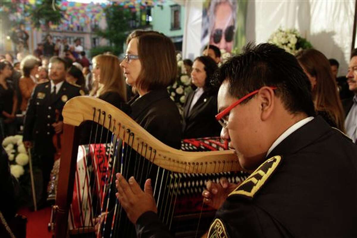 Mariachi musicians perform as city officials stand at honor guard next to the coffin of famed Mexican singer Chavela Vargas during a homage at the traditional Mariachi Garibaldi Plaza in Mexico City, Monday, Aug. 6, 2012. Chavela Vargas, who defied gender stereotypes to become one of the most legendary singers in Mexico, died Aug. 5 at age 93.