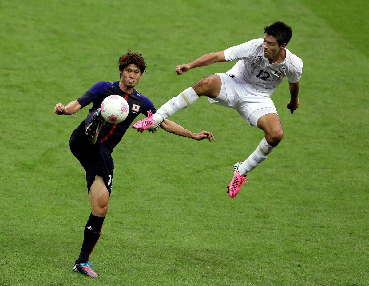 Mexico's Raul Jimenez, right, and Japan's Daisuke Suzuki vie for the ball during their semifinal soccer match at Wembley Stadium at the 2012 Summer Olympics, in London, Tuesday, Aug. 7, 2012. (AP Photo/Kirsty Wigglesworth)