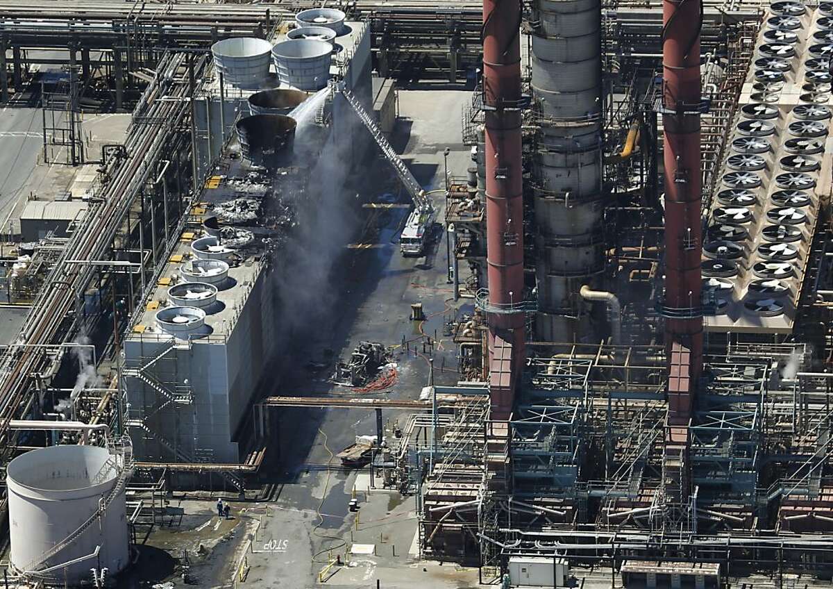 A fire truck continues to pour water on the No. 4 Crude Unit at the Chevron Refinery in Richmond, Calif. on Tuesday, Aug. 7, 2012, one day after an explosion and fire rocked the area and sent a giant plume of black smoke into the atmosphere.