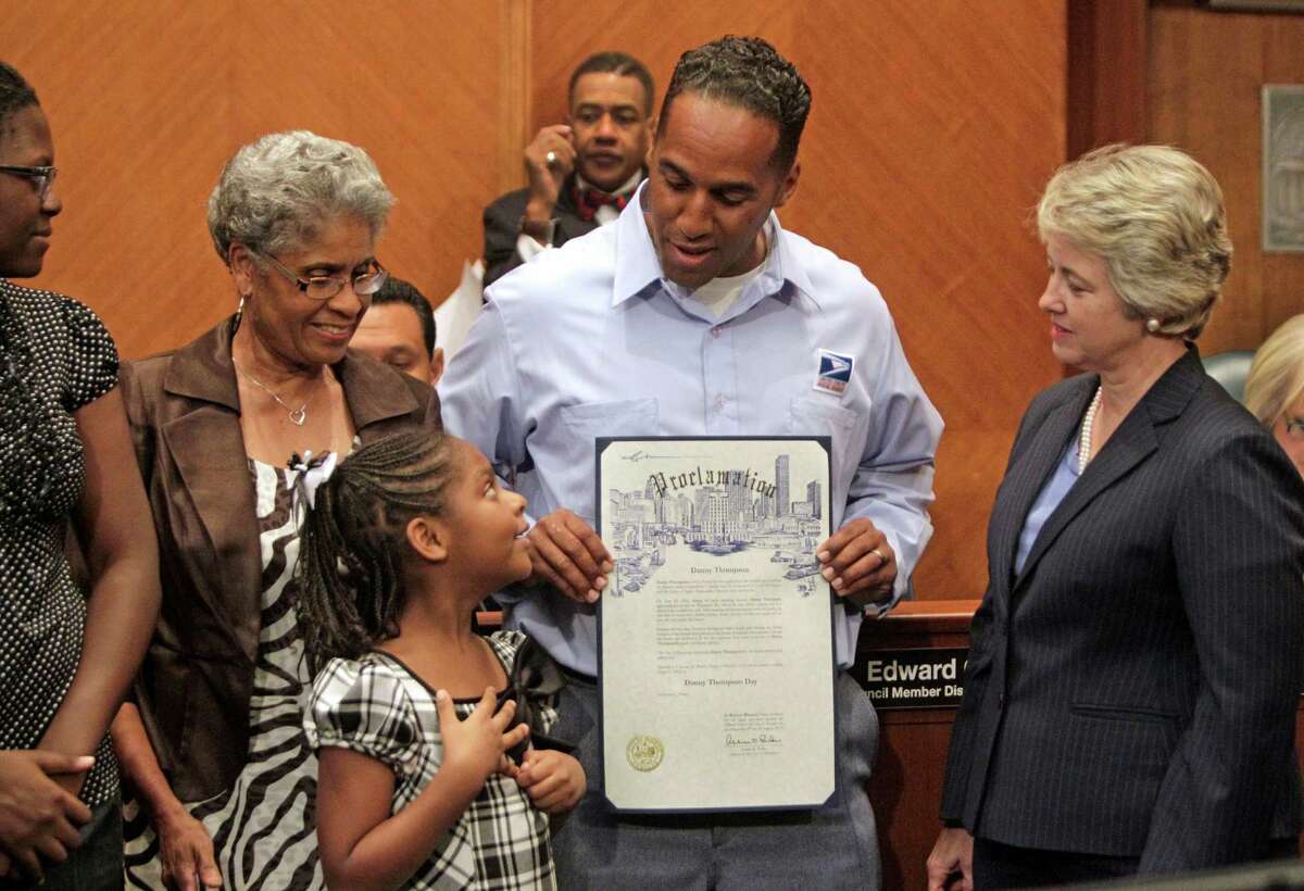 Chinyere Thompson, 15, her sister, Asia Thompson, 7, their grandmother, Dedriel Thompson, their dad, U.S. Postal Service employee Danny Thompson and City of Houston Mayor Annise Parker, right, line up to pose for photos after a proclamation declaring "Danny Thompson Day" during City Council's weekly meeting in the Council Chamber Tuesday, Aug. 7, 2012, in Houston. Thompson saved two children from a burning home while on his route. ( Melissa Phillip / Houston Chronicle )