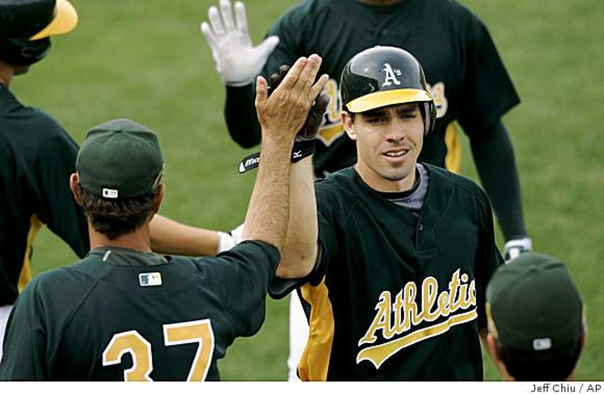 Oakland Athletics' Matt Carson, right, is congratulated after hitting a three-run home run off of Cleveland Indians' Rich Rundles in the sixth inning of their spring training baseball game in Phoenix, Ariz., Sunday, March 8, 2009. (AP Photo/Jeff Chiu)