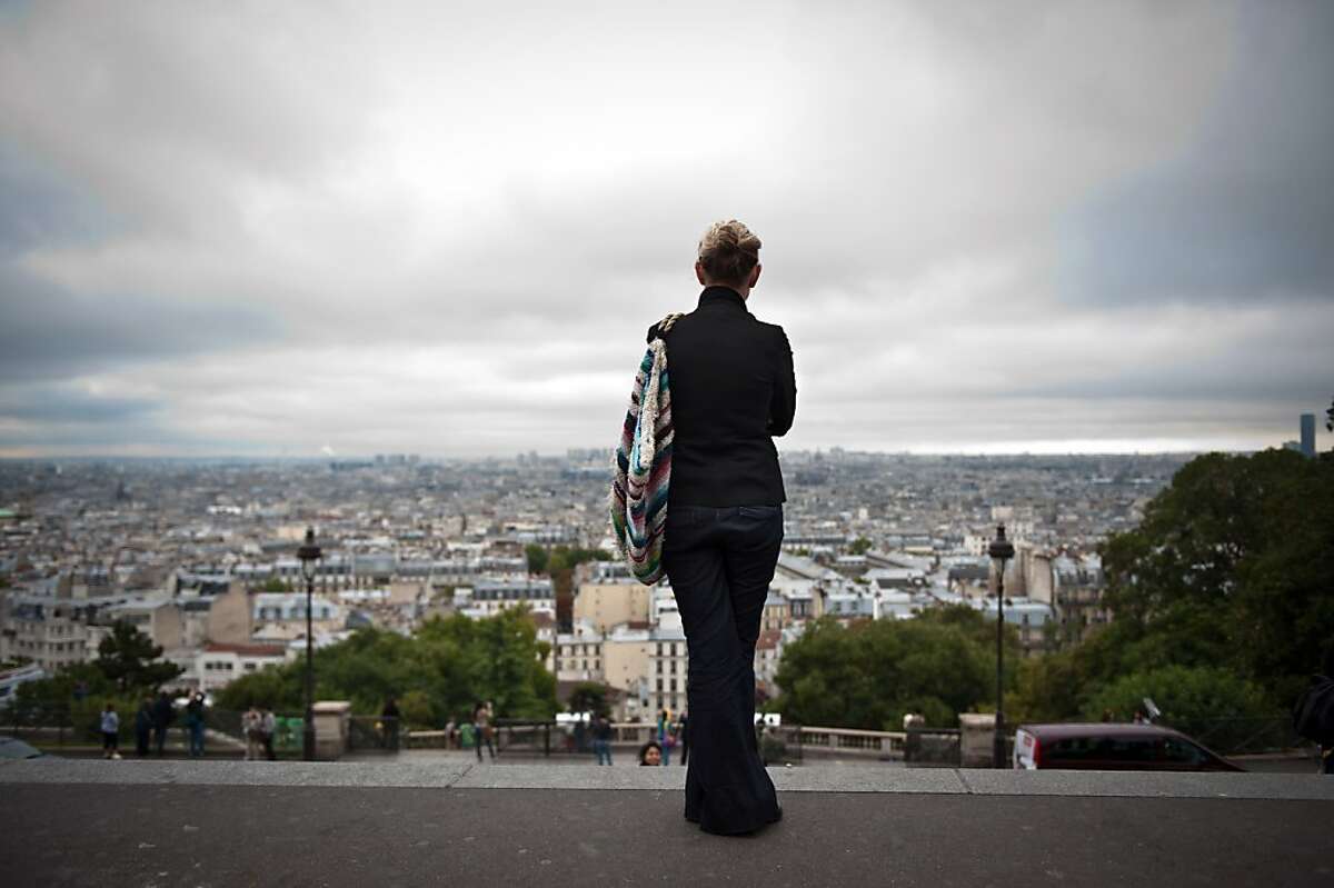A woman enjoys the view of Paris from the Sacre Coeur basilica esplanade, on September 24, 2010 in Paris.