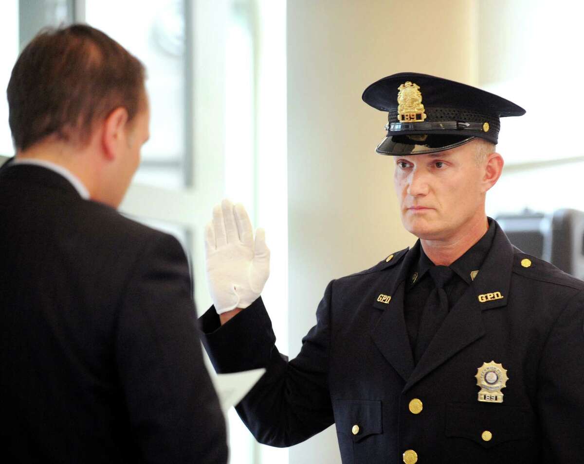 Greenwich First Selectman Peter Tesei, left, swears in Greenwich Police Officer Alton Hall as a sergeant during a promotion ceremony for Hall and Lt. James Bonney at Greenwich Police Headquarters, Thursday, Aug. 9, 2012.