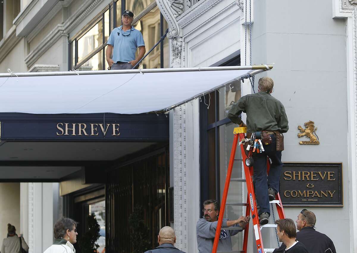 A production crew secures sun diffuser on the set of a new Woody Allen movie being filmed at Shreve and Co. jewelers at Post Street and Grant Avenue in San Francisco, Calif. on Friday, Aug. 10, 2012.