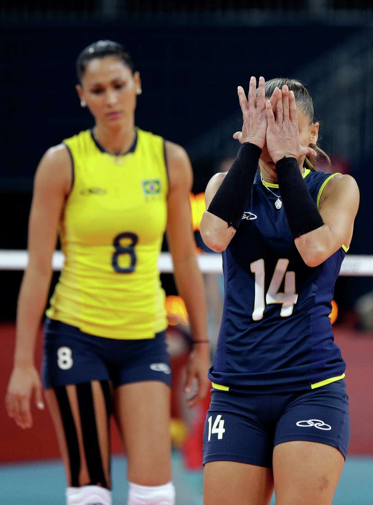 Brazil's Fabiana Oliveira (14) and Jaqueline Carvalho (8) react as the USA scores a point during a women's volleyball gold medal match at the 2012 Summer Olympics Saturday, Aug. 11, 2012, in London. (AP Photo/Chris O'Meara)