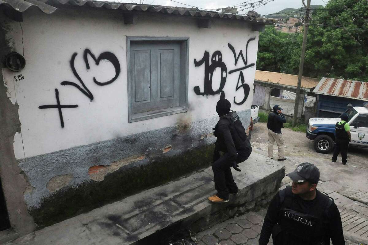 The National Police reclaim a home that had been seized by gangs in the 14 de Marzo neighborhood in Tegucigalpa, Honduras. Gang members seized the home after the owners fled, unable to pay extortion fees.