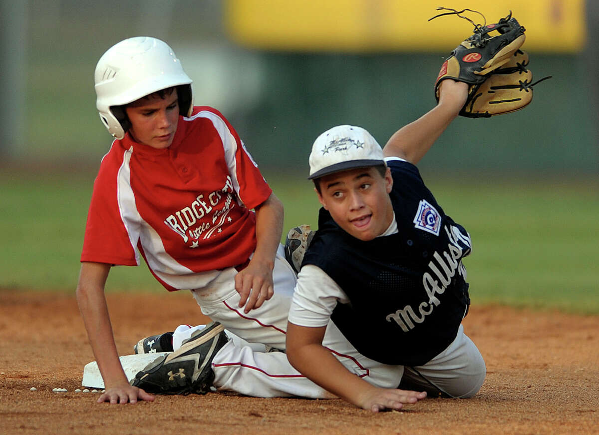 McAllister Park second baseman Nick Smisek (right) watches his throw reach first in time to complete a double-play. Matthew Kress of Bridge City also watches. McAllister Park won the game, 6-4, in Waco, to advance to the Little League World Series. Aug. 14, 2009.