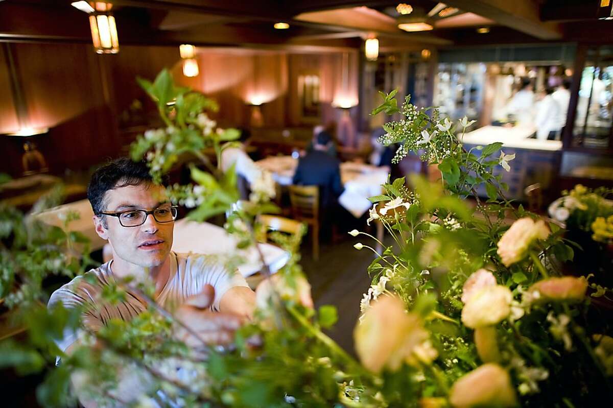 Max works on the display in the main dinning room using a mix of Bird Cherry Branches, Montana Clematis, Ranunculus, and Nasturtium flowers. Max Gill is a long time floral designer for Chez Panisse in Berkeley CA. Thursday April 26th, 2012.