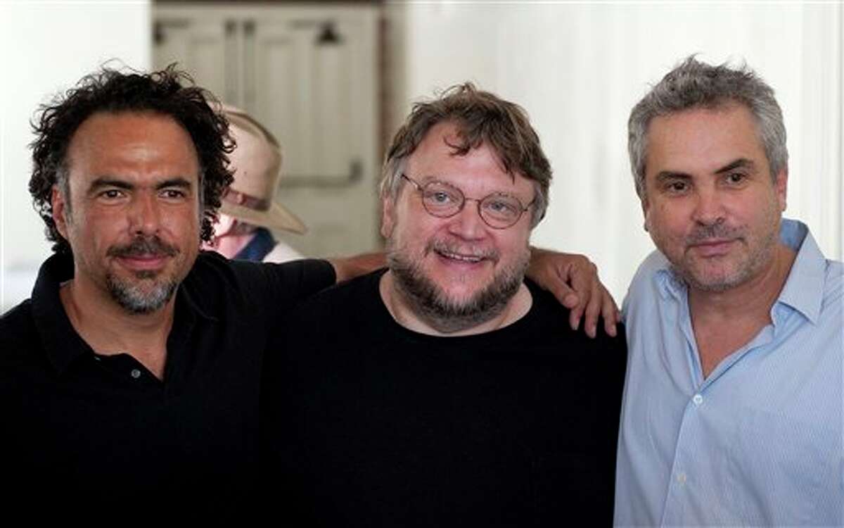 Directors Alejandro Gonz�lez I��rritu, left, Guillermo del Toro, middle, and Alfonso Cuar�n, right, pose for photos before a press conference held by the Caravan for Peace, in Los Angeles on Monday, Aug. 13, 2012. The caravan is traveling across the country to promote the alliance of the US and Mexico to fight the drug war. (AP Photo/Grant Hindsley)