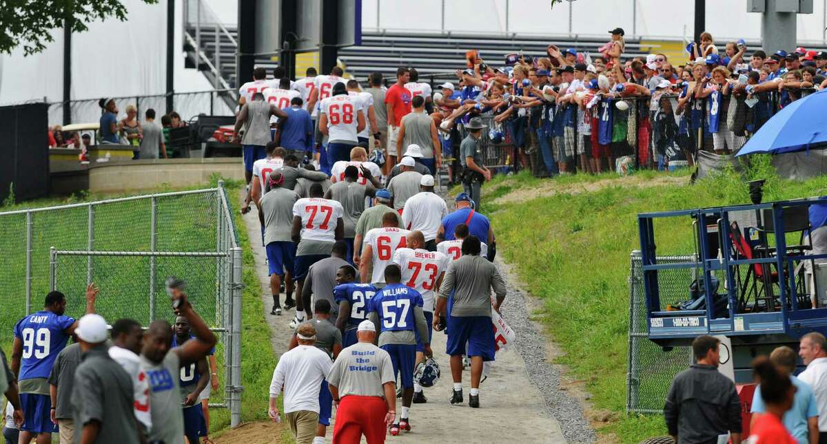 New York Giants players walk off the field as fans wait for autographs at the end of practice on the last day of training camp at UAlbany on Tuesday Aug. 14, 2012 in Albany, NY. (Philip Kamrass / Times Union)