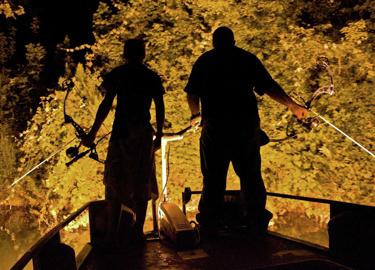 Robert Blackburn (left) and his father, Walter Blackburn, use bright lights to illuminate the water late at night while they are bowfishing. "Bowfishing is … one of the most fun things you can do," Robert says. "There is nothing that I don't like about it, other than you have to sleep most of the next day."﻿