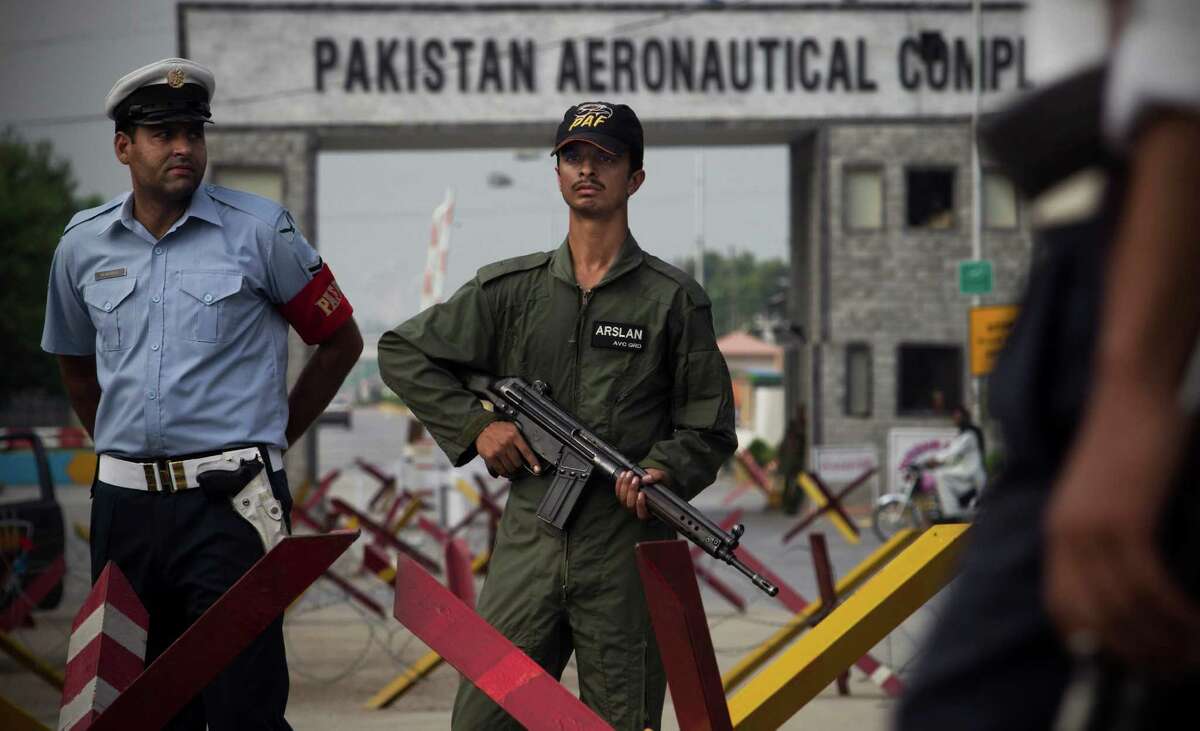Pakistani security stand guard at the entrance of Pakistan's air force base in Kamra about 85 kilometers (50 miles) northwest of Islamabad, Pakistan, Thursday, Aug. 16, 2012. Militants attacked an air force base in northwest Pakistan filled with F-16s and other aircraft before dawn Thursday, sparking a heavy battle with security forces that left parts of the base in flames, officials said. (AP Photo/B.K. Bangash)