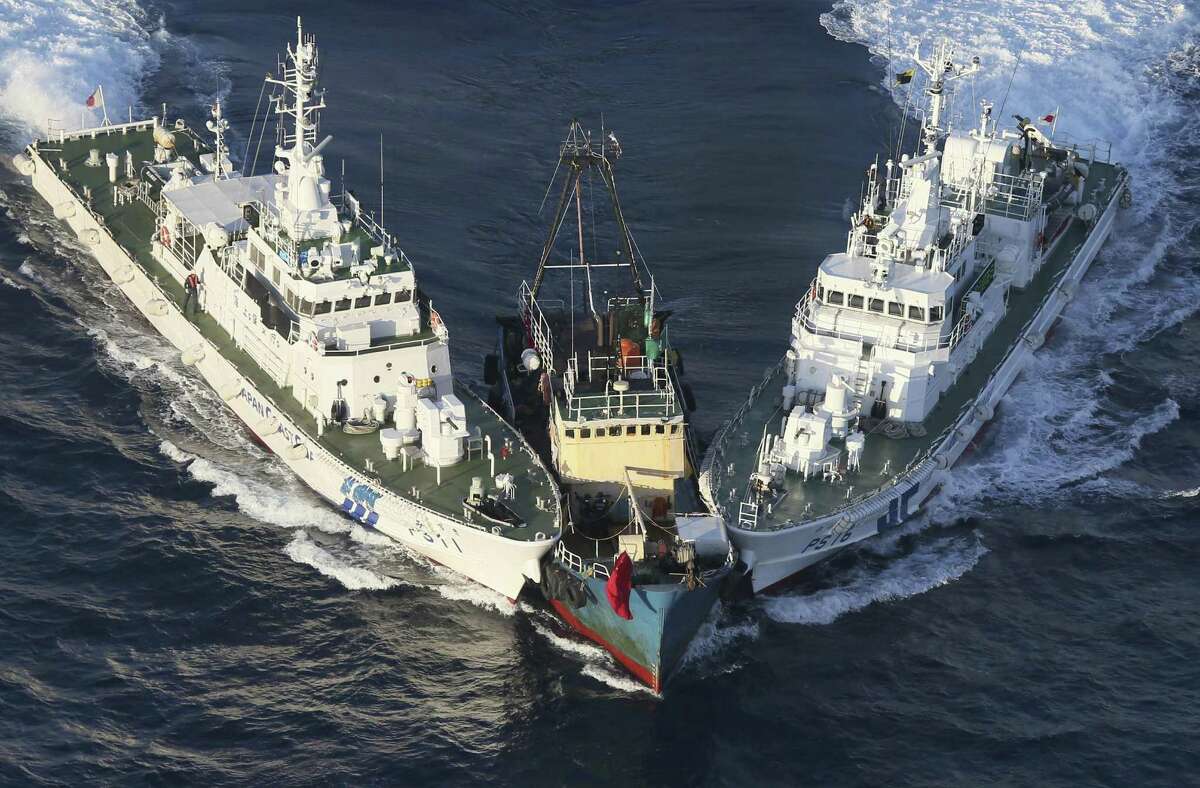 A boat is surrounded by Japan Cost Guard patrol boats after some activists descended from the boat on Uotsuri Island. The island is controlled by Japan but claimed by China as 14 activists were detained Aug. 15.