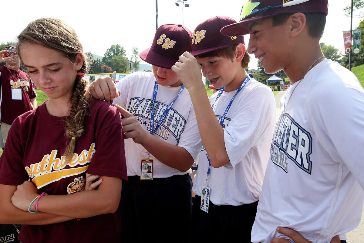 Sarina Lauchle, 12, of Milton, Pennsylvania, gets her tee-shirt autographed by members of the McAllister Park National LIttle League on the first day of the 2012 Little League World Series in South Williamsport, Pa., Thursday, Aug. 16, 2012. The team, representing the Southwest Champions will face off with the Mid-Atlantic Champions from Parsippany, New Jersey, Friday afternoon. Signing the shirt are from left, Carter Elliott, 13, Mason Moore, 12 and Grant Gomez, 13.