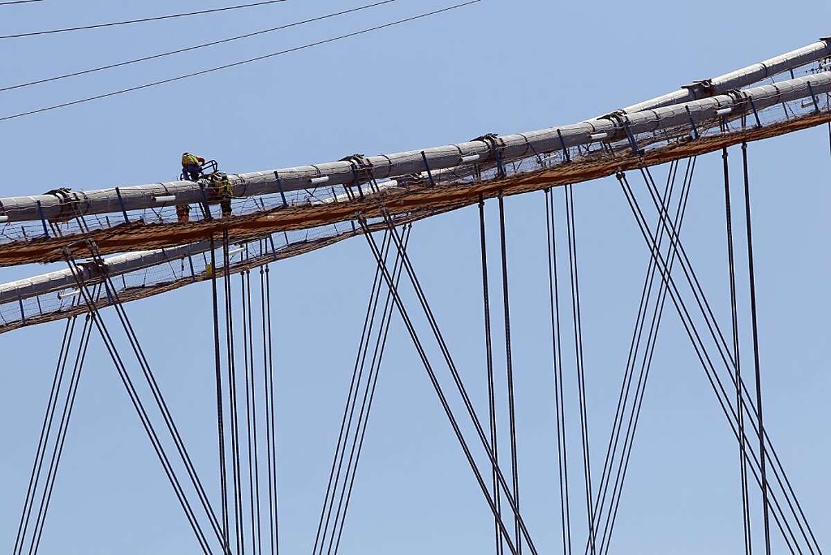 A work crew tightens the pressure on suspension cables on the span cables of the new eastern span of the Bay Bridge on Thursday, August 16, 2012, in San Francisco, Calif., Crews on the new east span of the Bay Bridge are preparing to start "transfering the load" or lifting the suspension section of the new bridge onto the suspension cables and off of the temporary trestles that have supported it during construction.