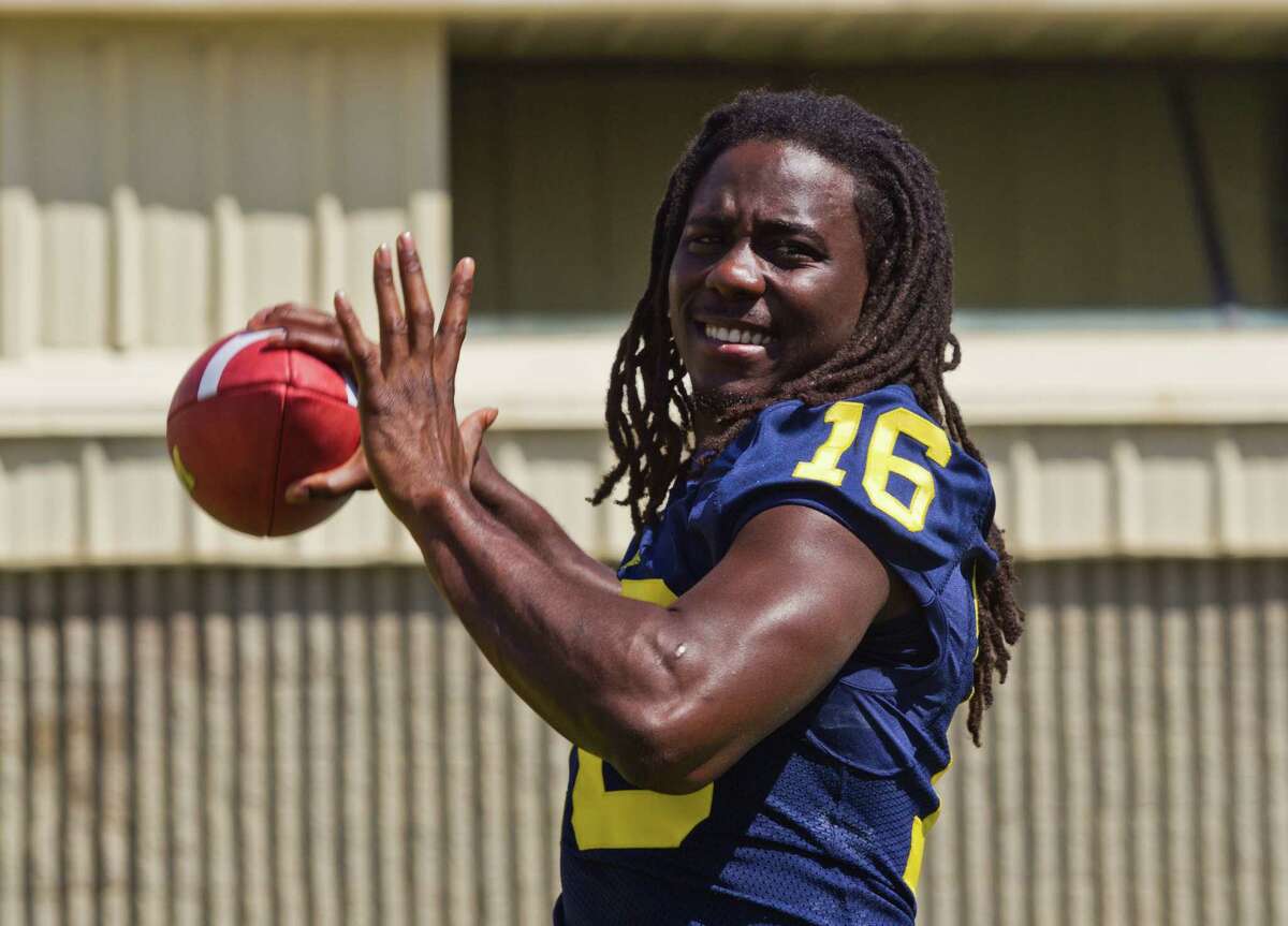 Michigan quarterback Denard Robinson throws passes for photographers during the NCAA college football team's annual media day on Sunday in Ann Arbor, Mich. (AP Photo/Tony Ding)