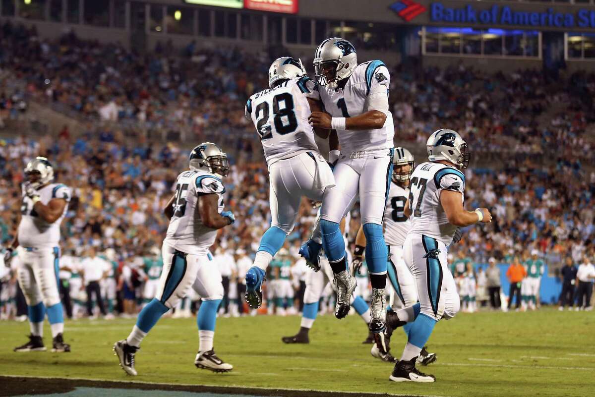 Cam Newton (1) celebrates with teammate Jonathan Stewart after the running back scored a touchdown.