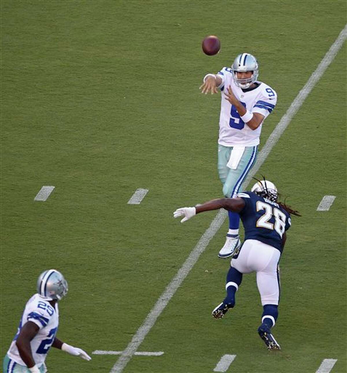 Dallas Cowboys quarterback Tony Romo throws a pass over San Diego Chargers defensive back Atari Bigby to running back DeMarco Murray in the flat during the first quarter of a NFL preseason football game Saturday, Aug. 18, 2012 in San Diego. (AP Photo/Lenny Ignelzi)