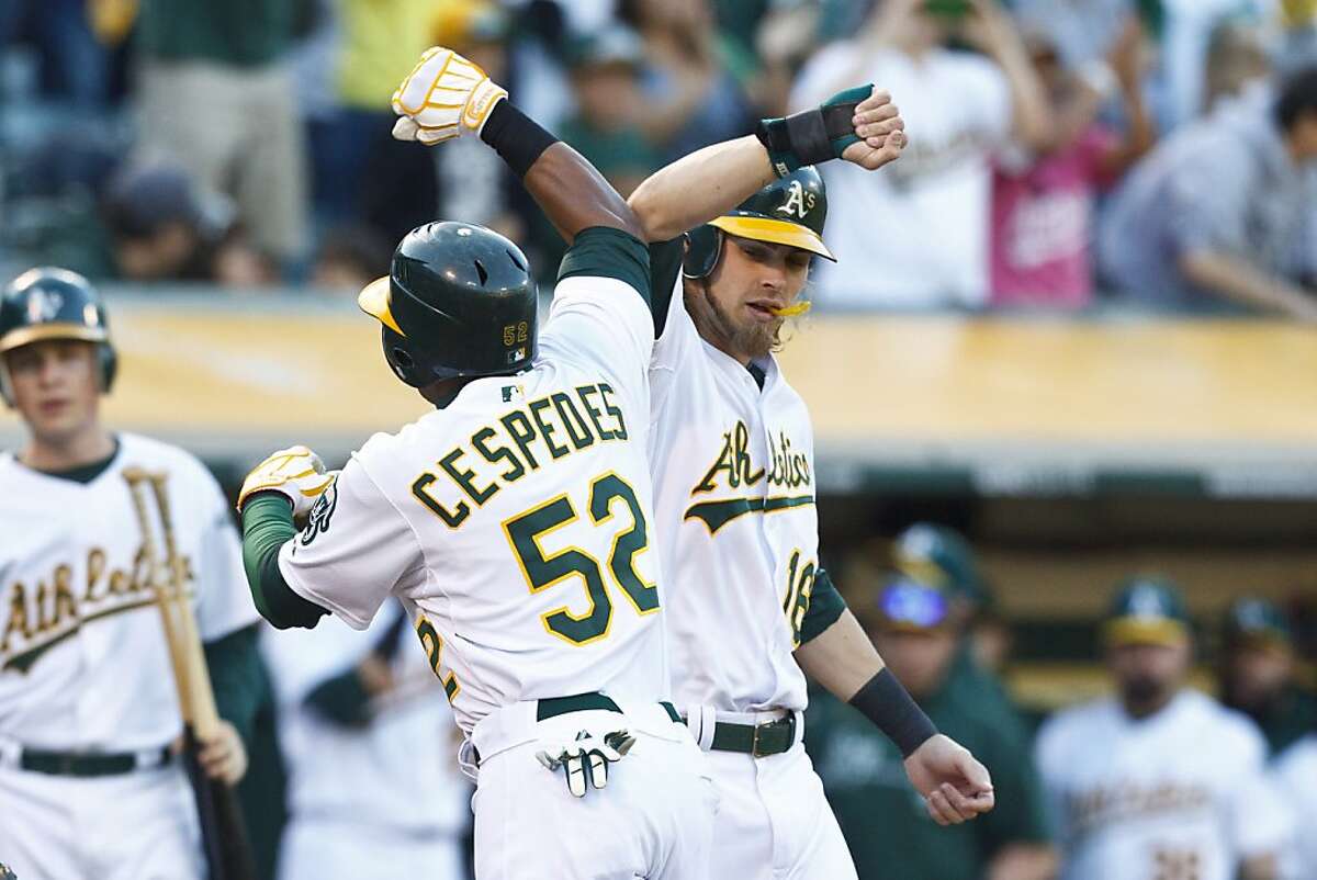OAKLAND, CA - AUGUST 18: Yoenis Cespedes #52 of the Oakland Athletics is congratulated by Josh Reddick #16 after hitting a two run home run against the Cleveland Indians during the third inning at O.co Coliseum on August 18, 2012 in Oakland, California. (Photo by Jason O. Watson/Getty Images)
