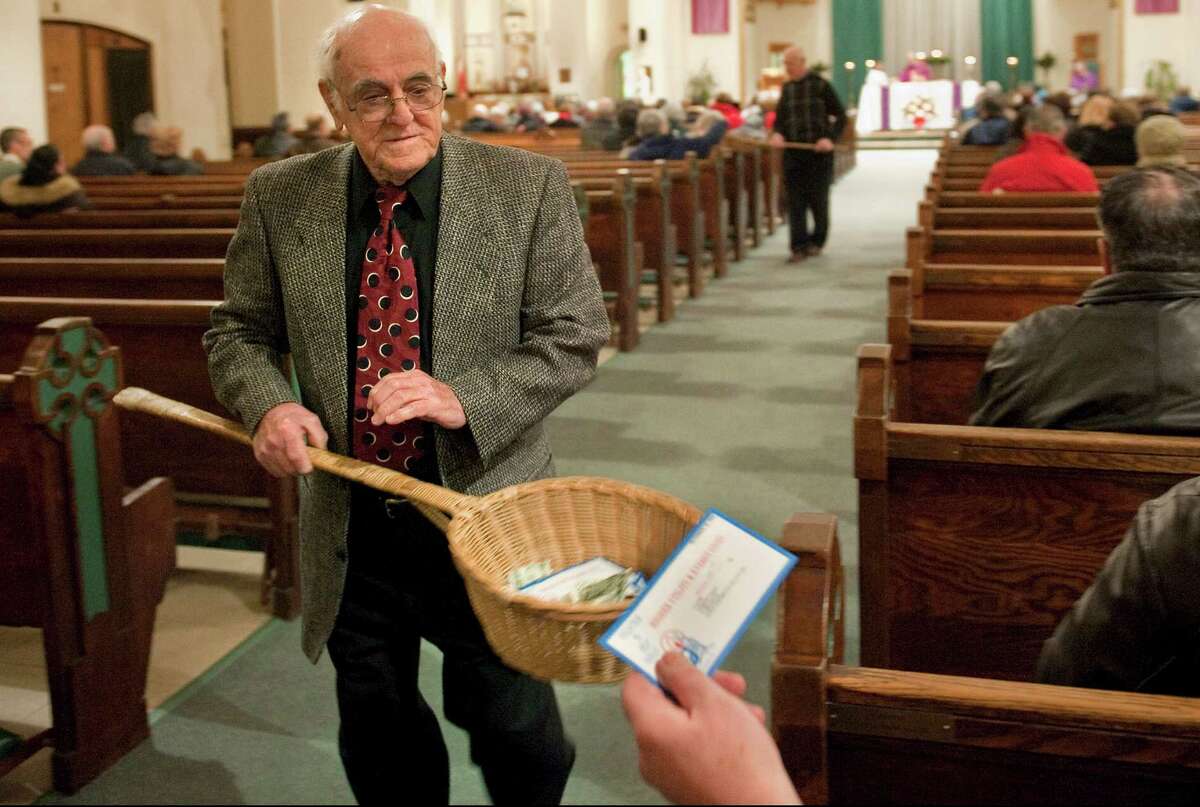 In this Saturday, Dec. 19, 2009 photo, John Alves, of Dartmouth, Mass., uses a basket while taking collection during Mass at St. John the Baptist Roman Catholic Church in New Bedford, Mass. A study on the generosity of Americans, released Monday, Aug. 20, 2012, by the Chronicle of Philanthropy, found that states with populations that are less religious are also the stingiest about giving money to charity. (AP Photo/Gretchen Ertl)