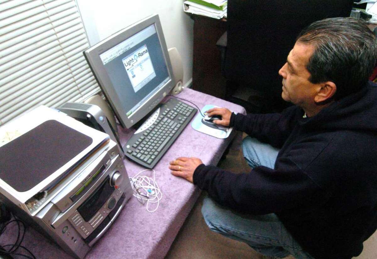 Chris Pacheco, of Danbury, works on a computer system to help run a lighting show for Christmas at his home in Danbury, Friday, Dec. 4, 2009. Donations are accepted and will be given to Ann's Place for the I Can foundation.