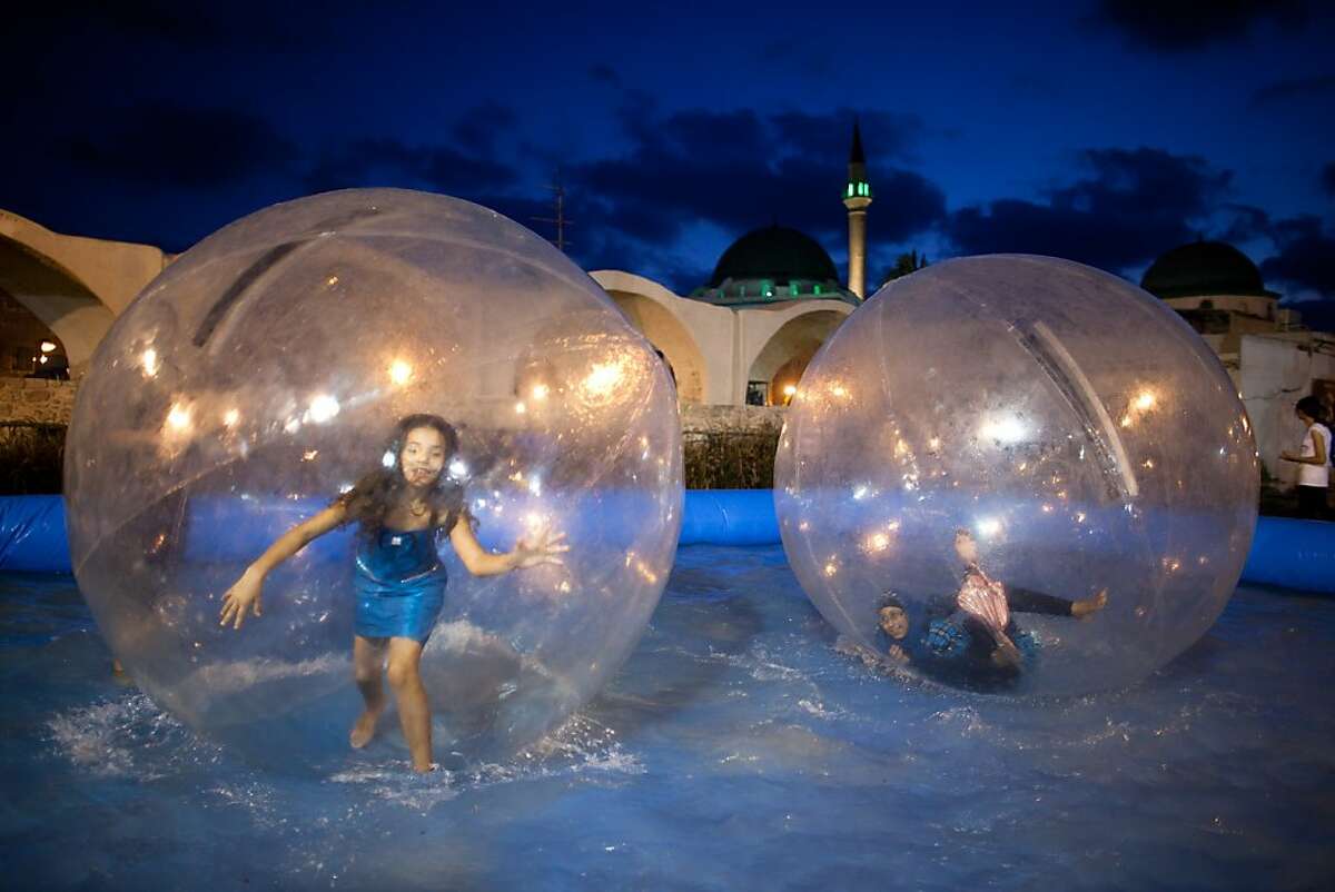 Israeli Arab children play inside an air ball in a swimming pool at an amusement park as Muslims celebrated the Eid al-Fitr holiday, which marks the end of the holy fasting month of Ramadan on August 20, 2012 at the old city of Acre, Israel. (Photo by Uriel Sinai/Getty Images)