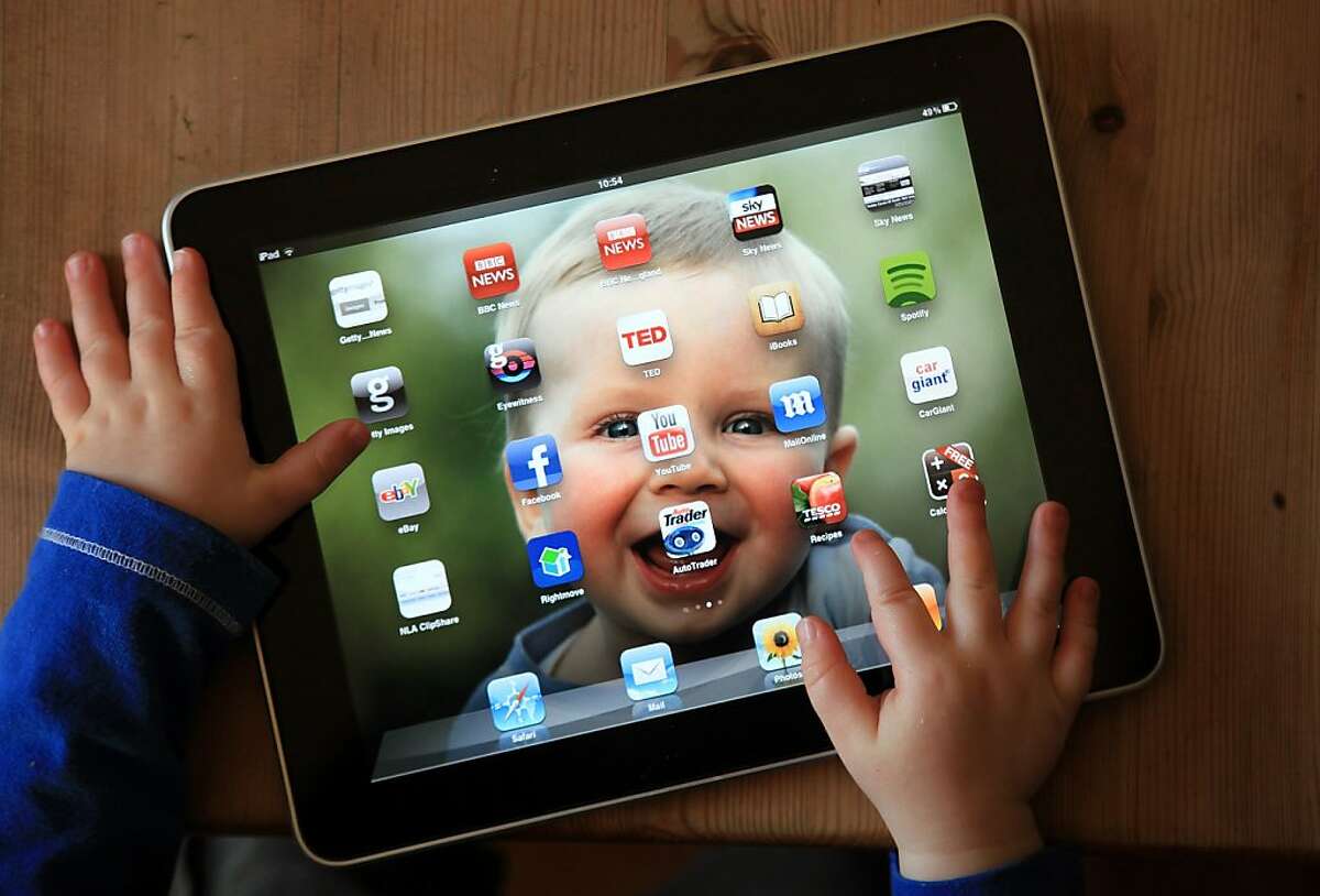 GLASTONBURY, UNITED KINGDOM - NOVEMBER 25: In this photo illustration 13-month old Zac Cardy uses a iPad at his home on November 25, 2011 in Glastonbury, United Kingdom. Tablet computers have become the most wanted Christmas present for children between the ages of 6-11 years. Many parents are having to share their tablet computers with their children as software companies release hundredes of educational and fun applications each month. (Photo by Matt Cardy/Getty Images)