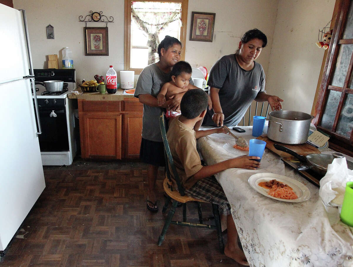 In Hidalgo County, Sonia Garcia, 33 (right), serves lunch to her family in the North San Carlos Colonia. She and her husband have five U.S.-born children and receive $739 in benefits each month.