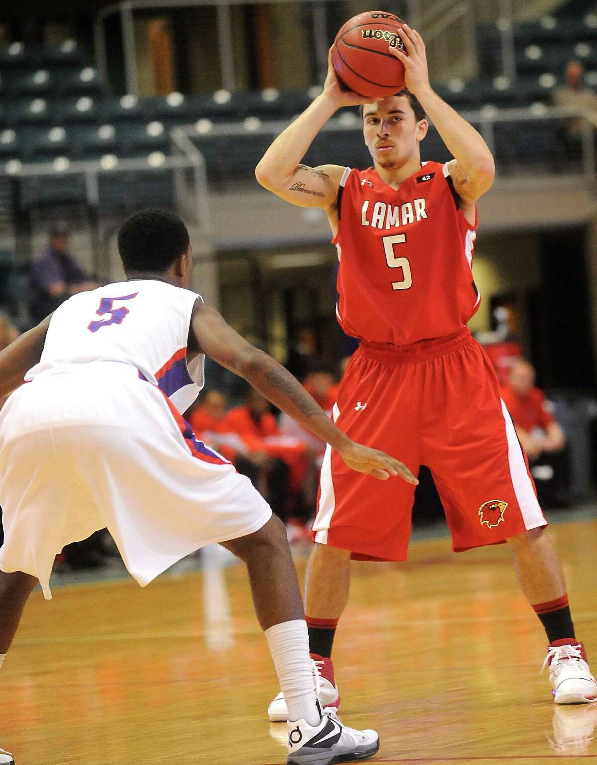 Lamar's Mike James looks to pass over SFA's Antonio Bostic at the Merrell Center in Katy, Thursday, March 8, 2012. Tammy McKinley/The Enterprise