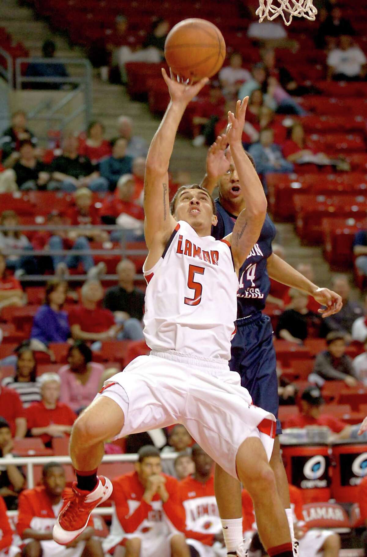 Lamar's Mike James goes up for two points as Lyon College's Kendall Leeks defends at the Montagne Center at Lamar University, Saturday, December 31, 2011. Tammy McKinley/The Enterprise