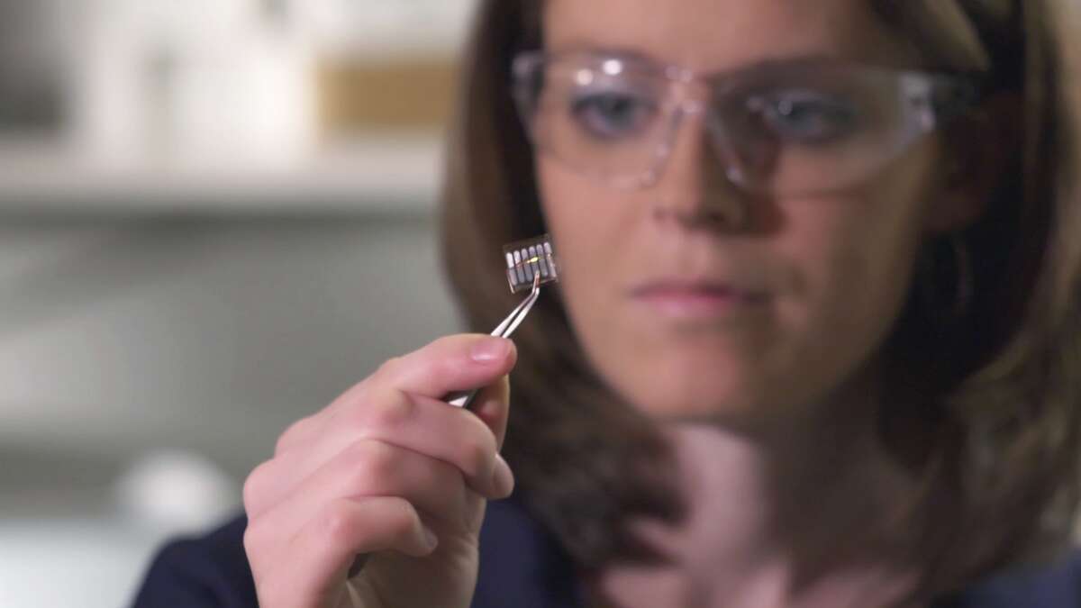 Kathy Woody, associate scientist for the Phillips 66 alternative energy team, examines an organic photovoltaic cell.