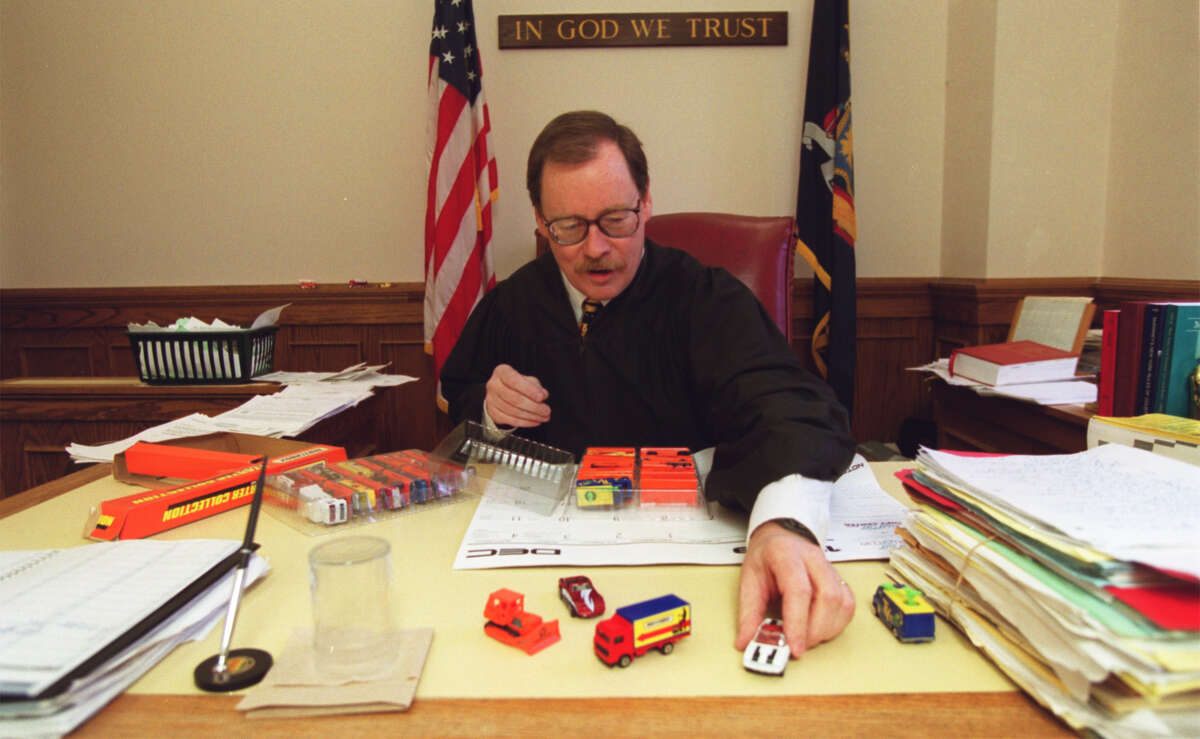 Former Family Court Judge Bryan Hedges puts out new model cars for children who come into his court in 1999. He says all kids get to take home a car or truck. (C. W. McKeen / Courtesy of The Syracuse Post-Standard)