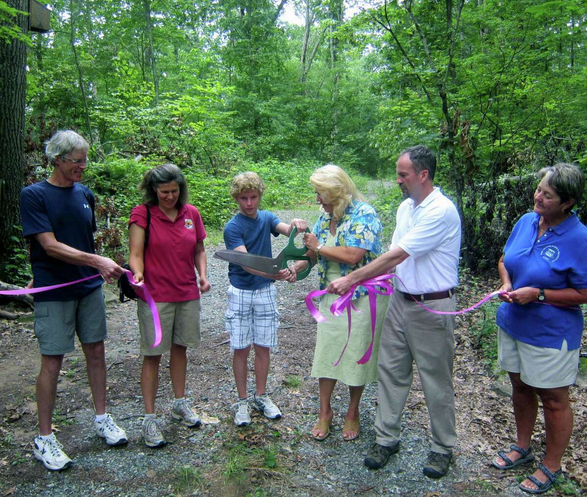 Mayor Pat Murphy and Jake O'Brien do the honors Aug. 14 at an official ribbon-cutting to celebrate the Sega Meadows Park bike trail in New Milford. Enjoying the moment are, from left to riight, Jake's father, bicycling advocate Tom O'Brien, Molly Sperduto of the United States Fish and Wildlife Service, and, right, New Milford Parks & Recreation director Dan Calhoun and assistant director Eleanor Covelli.