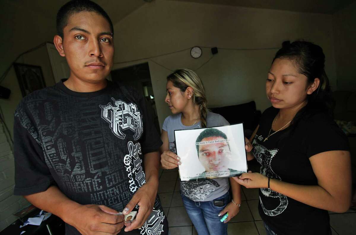 Nereo Diaz, 23, left to right, Elda Diaz, 24, and Luci Diaz, 21, siblings of Victor Diaz, whose body was found in the Pearl Brewery smokestack, hold a photo of him in at Nereo's house. The family is from Chiapas. Wednesday, August 22, 2012.