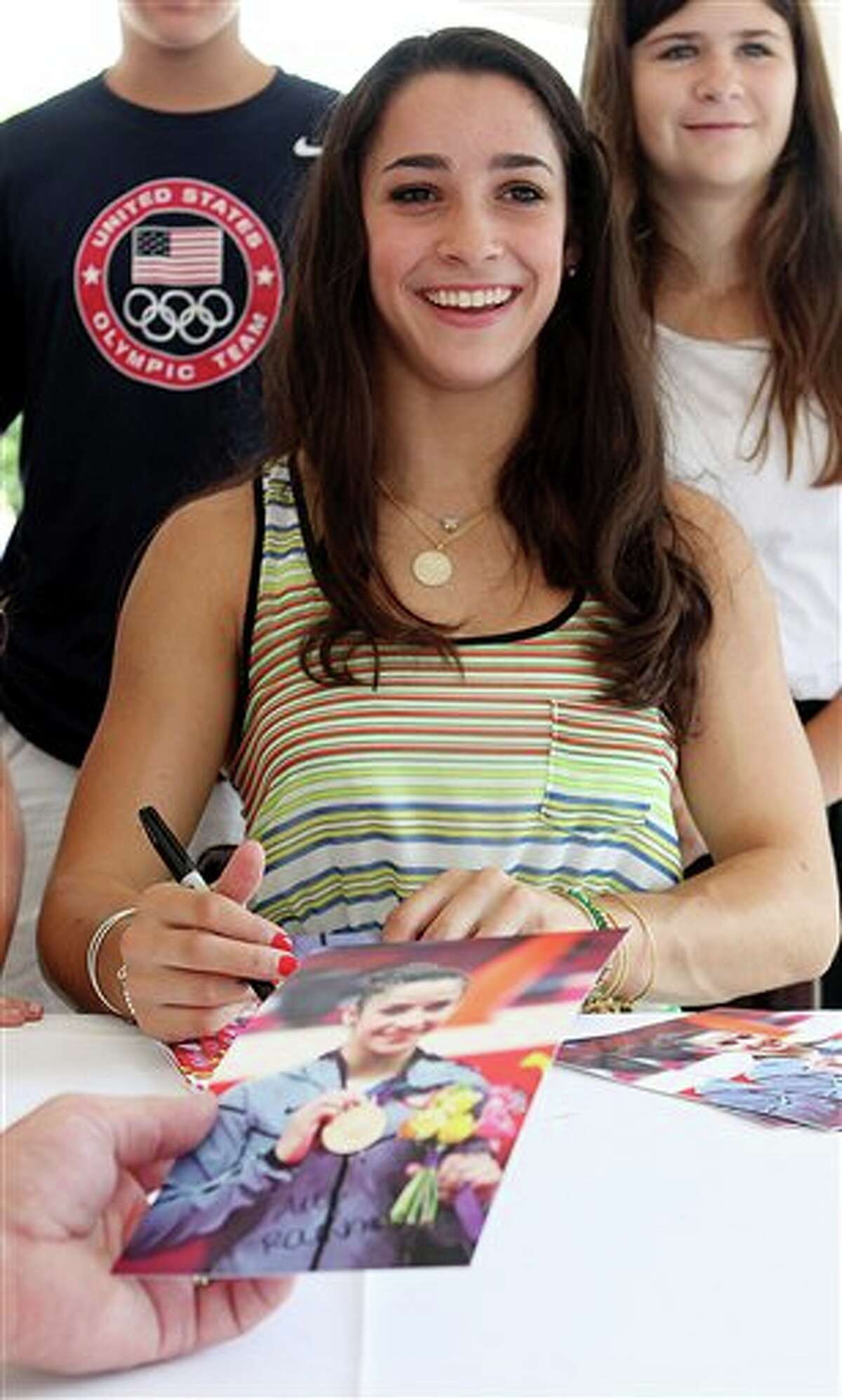 Olympic gold medal-winning gymnast Aly Raisman, right, signs autographs during a visit to Brestyan's American Gymnastics Club, Thursday, Aug. 16, 2012, in Burlington, Mass. Hundreds of children and parents and even a pony turned out Thursday to welcome Raisman back to the gym where she trains. (AP Photo/The Boston Herald, Angela Rowlings) BOSTON GLOBE OUT; METRO BOSTON OUT; MAGS OUT; ONLINE OUT